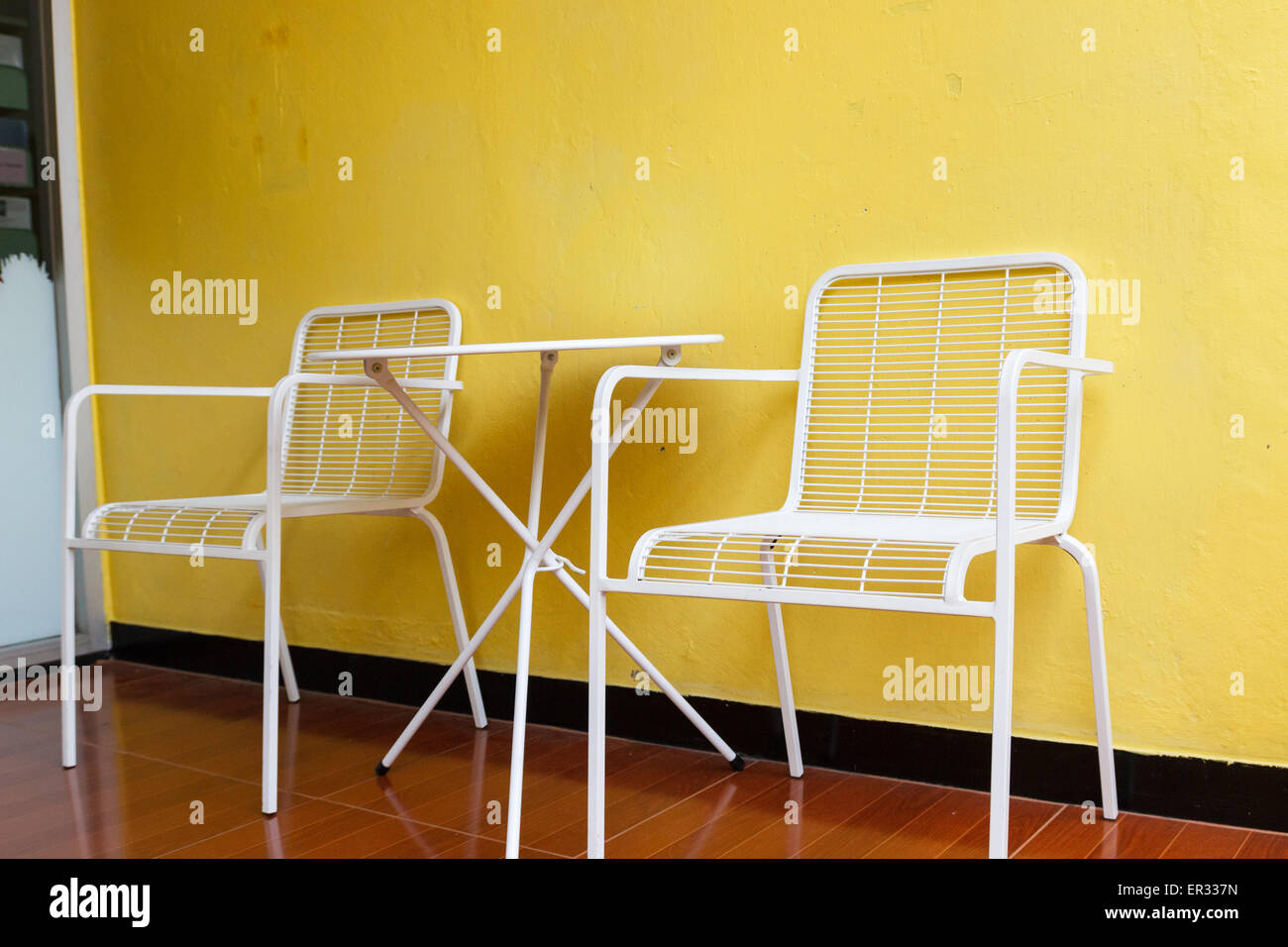 white metal chair and desk with yellow wall Stock Photo Alamy