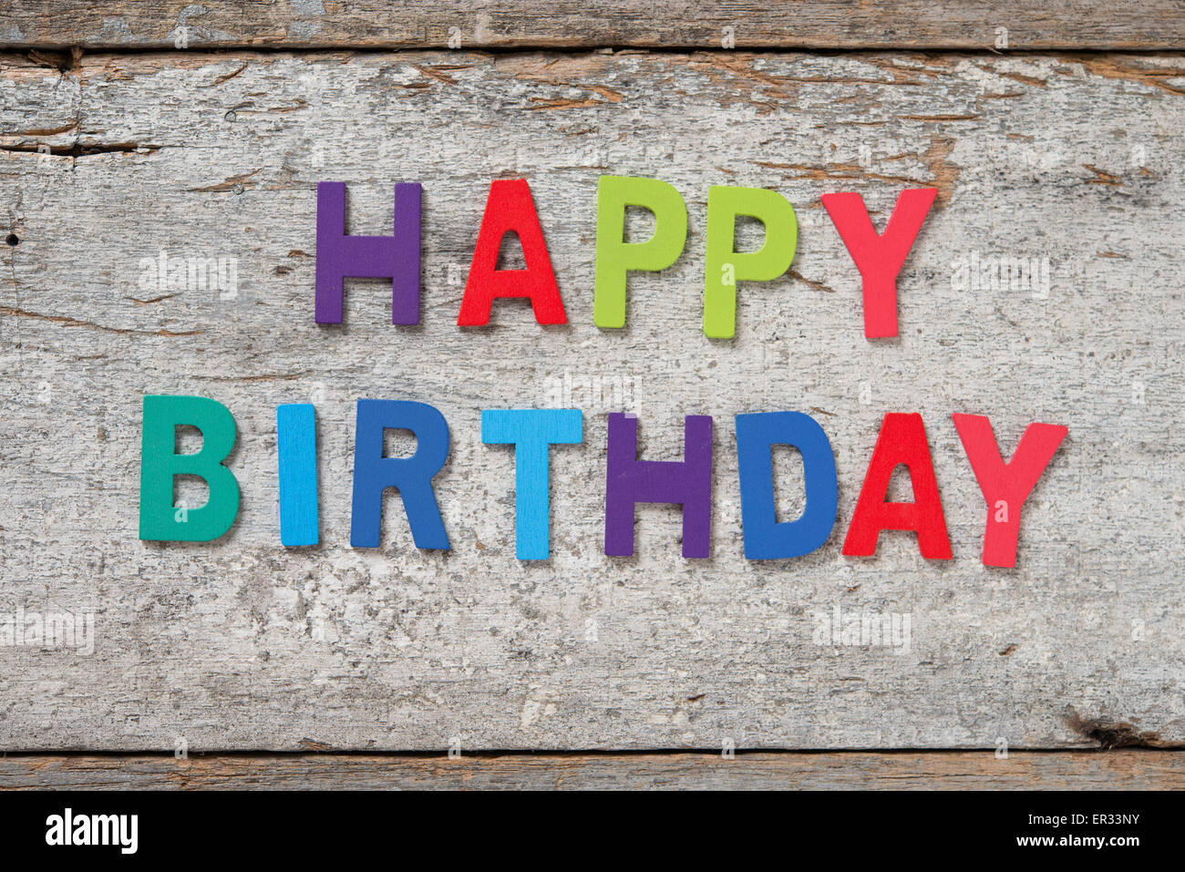 The colorful words "HAPPY BIRTHDAY" made with wooden letters on old ...