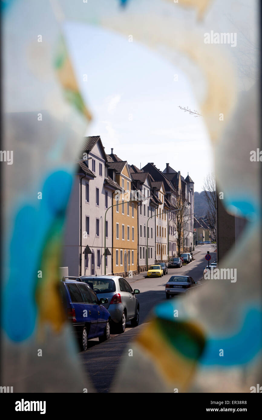 Europe, Germany, North Rhine-Westphalia, Hagen, view through a broken and painted pane of a bus stop to houses in the district V Stock Photo