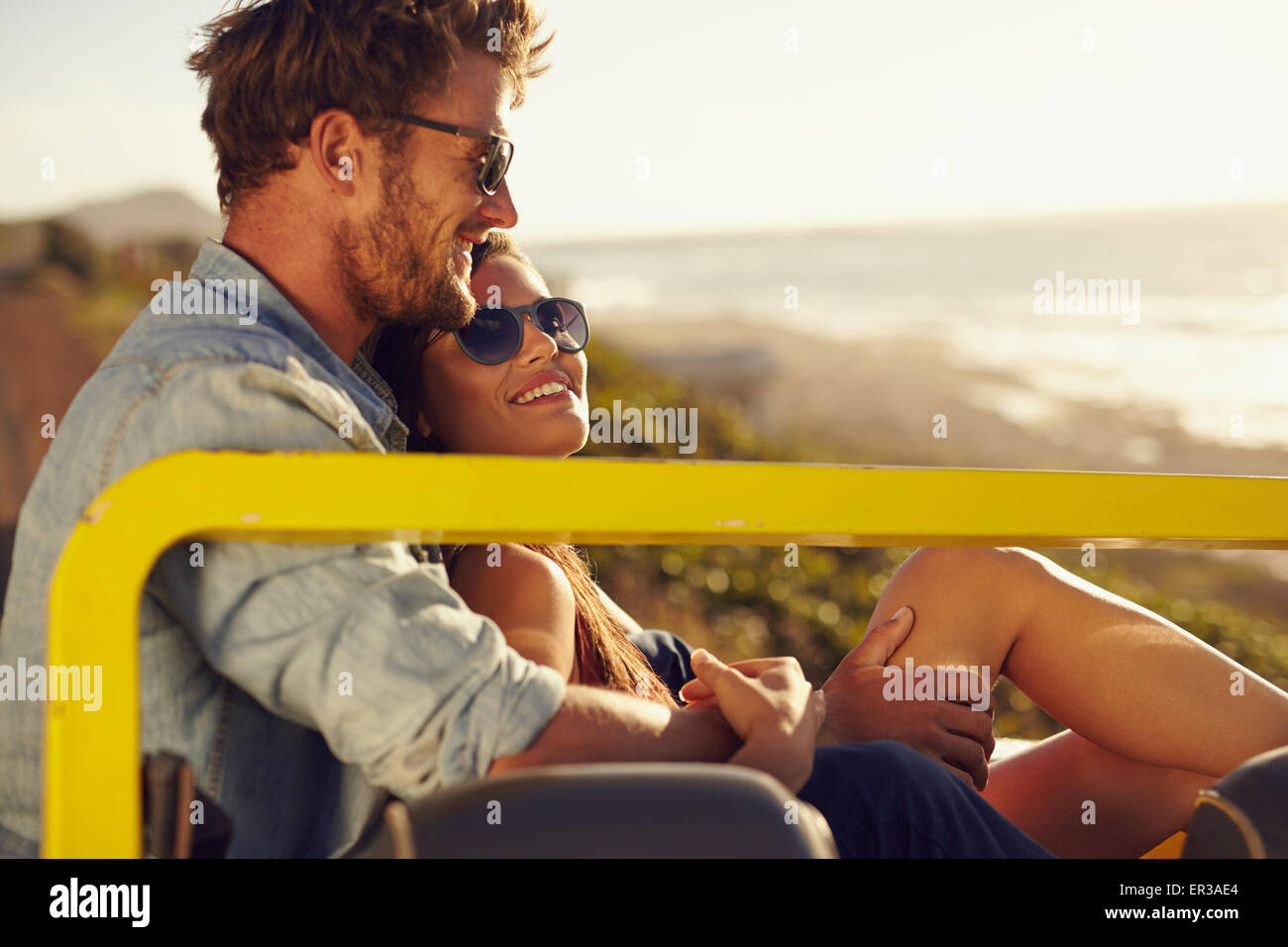 Portrait of beautiful young couple sitting together in a car smiling on ...