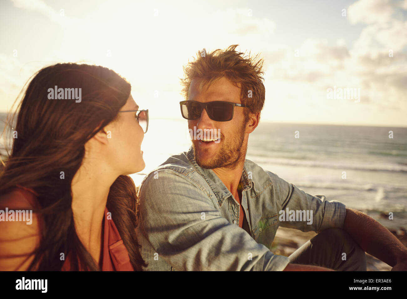 Close-up portrait of loving young couple looking at each other at the beach. Romantic caucasian couple in love on summer holiday Stock Photo