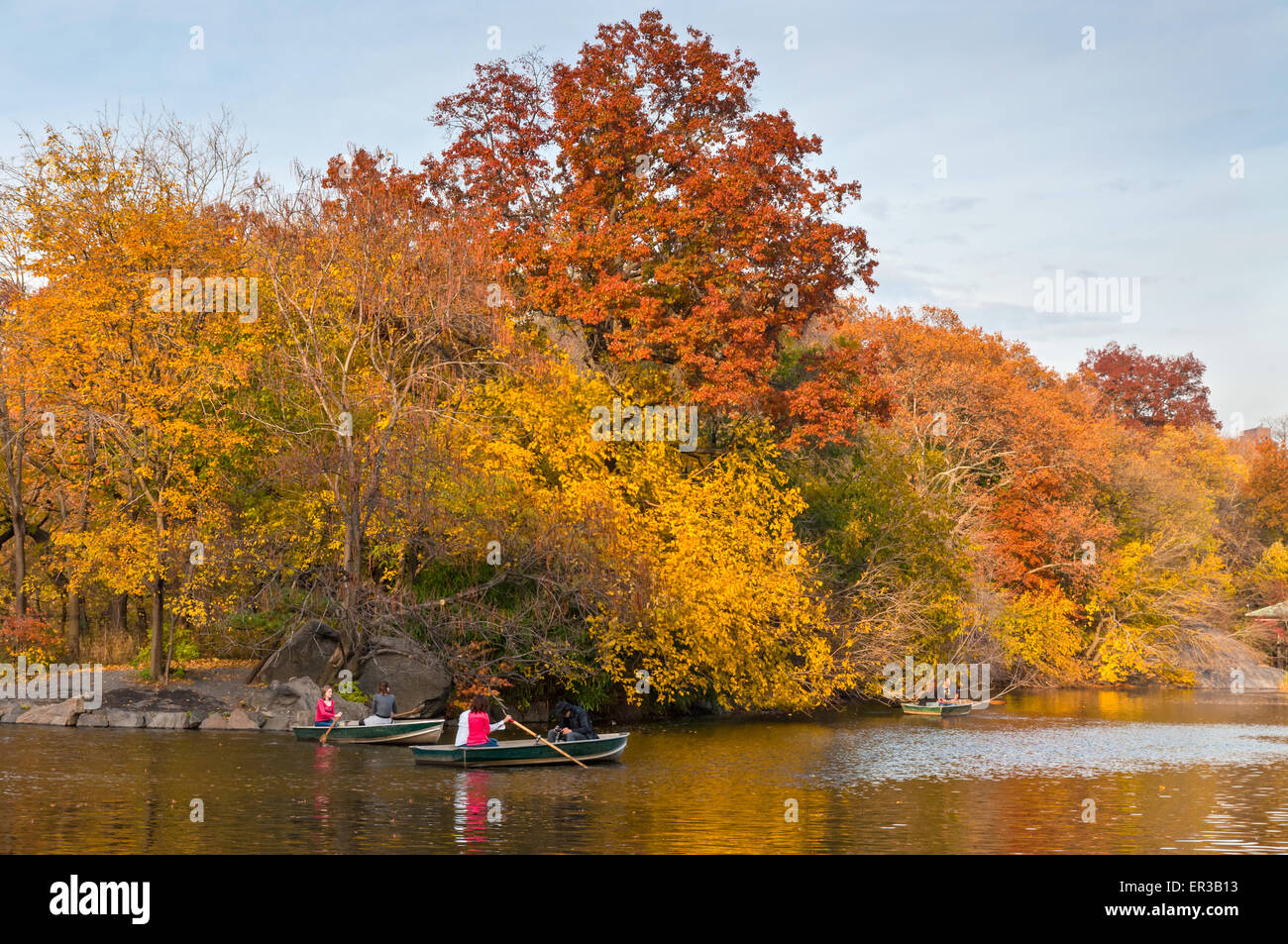 People row in recreational boats on a lake in beautiful autumn Central Park, NYC. Stock Photo