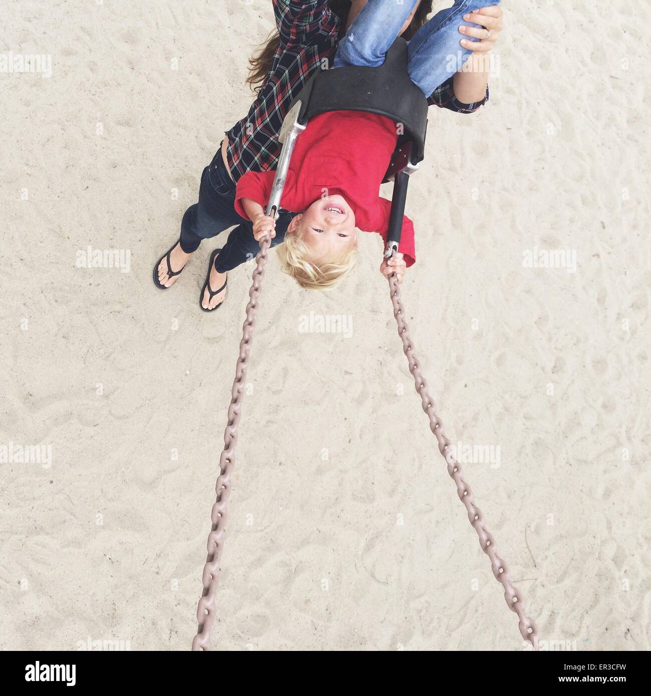 Elevated view of a woman pushing her son on a swing Stock Photo