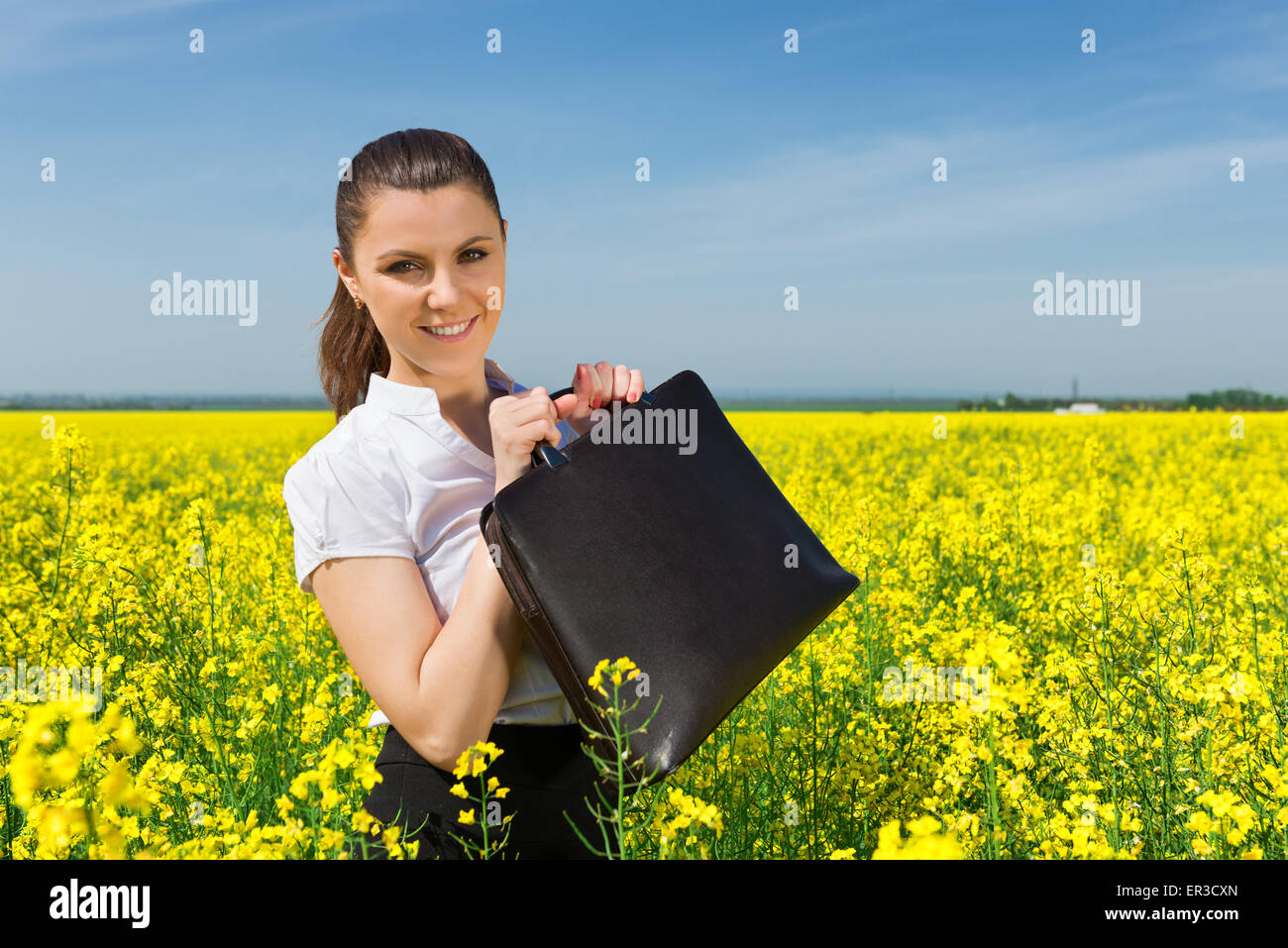 girl with a briefcase on yellow flower field Stock Photo - Alamy
