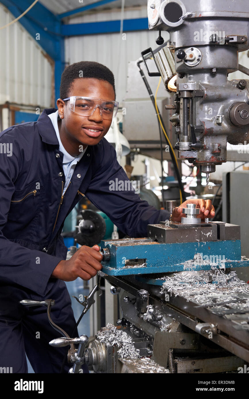 Male Apprentice Engineer Working On Drill In Factory Stock Photo
