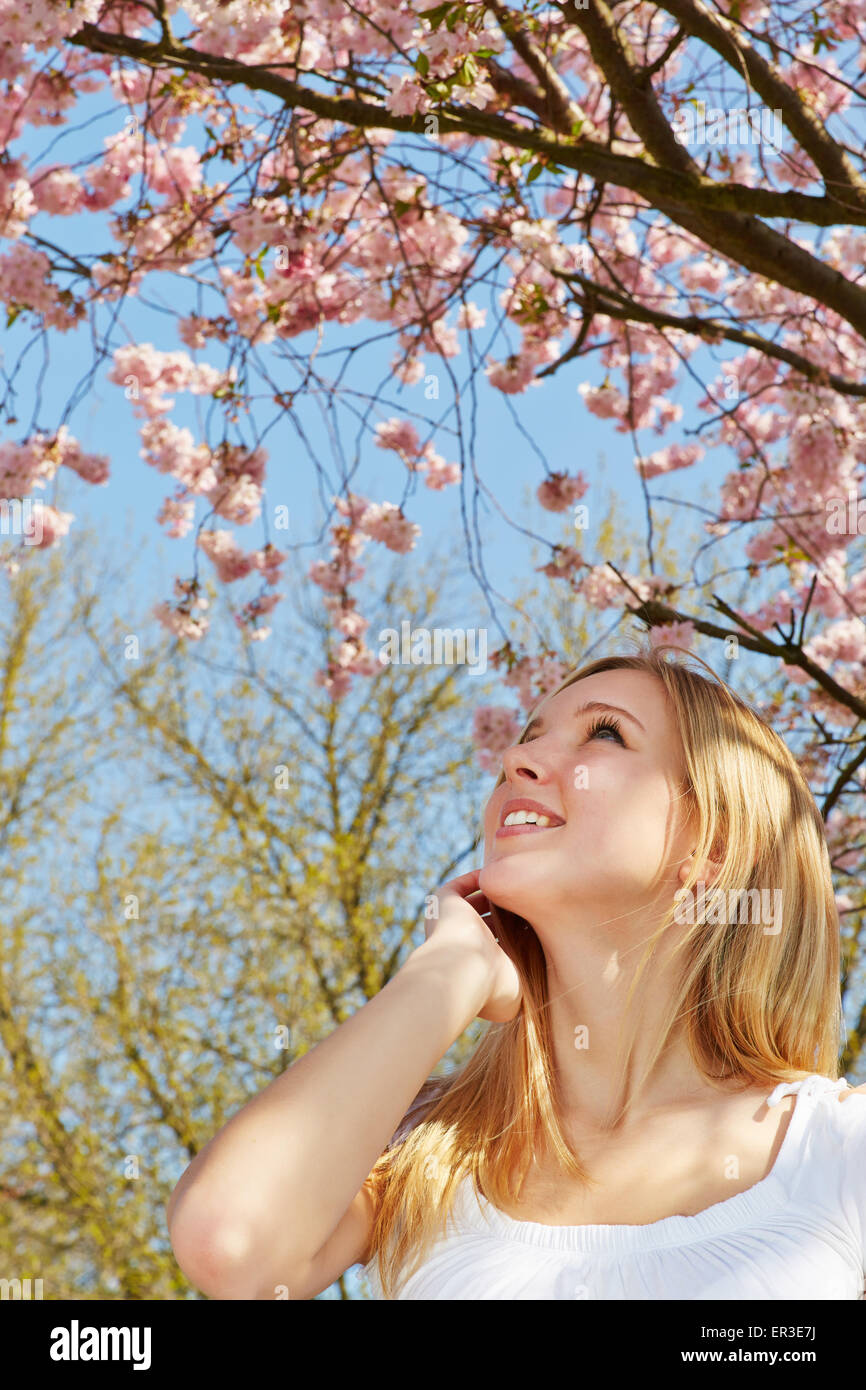 Young woman standing under a blooming cherry tree in spring Stock Photo ...