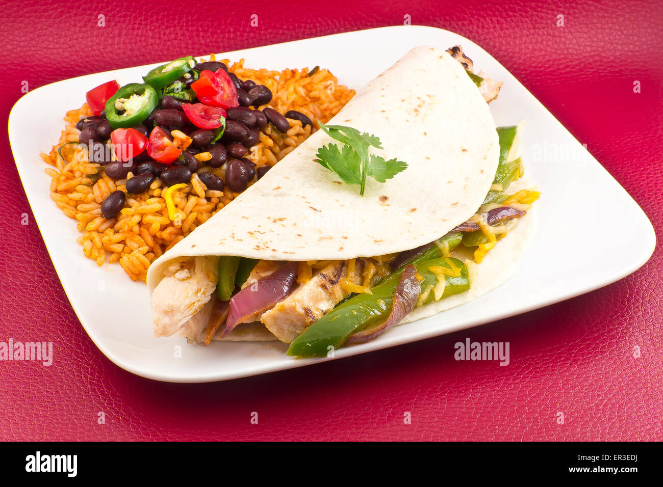 Mexican chicken fajita with green bell pepper slices and red onion in a flour tortilla, with