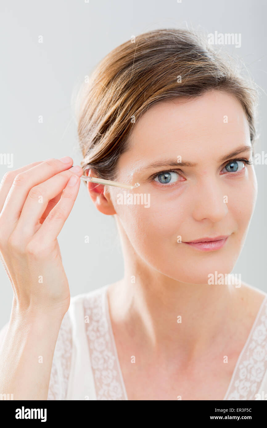 Woman using serum eye contour. Stock Photo