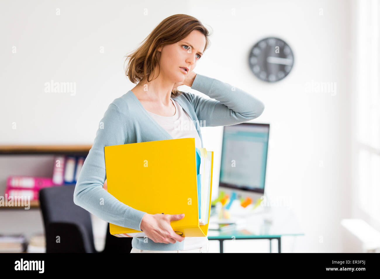 Woman suffering from neck pain in office Stock Photo - Alamy