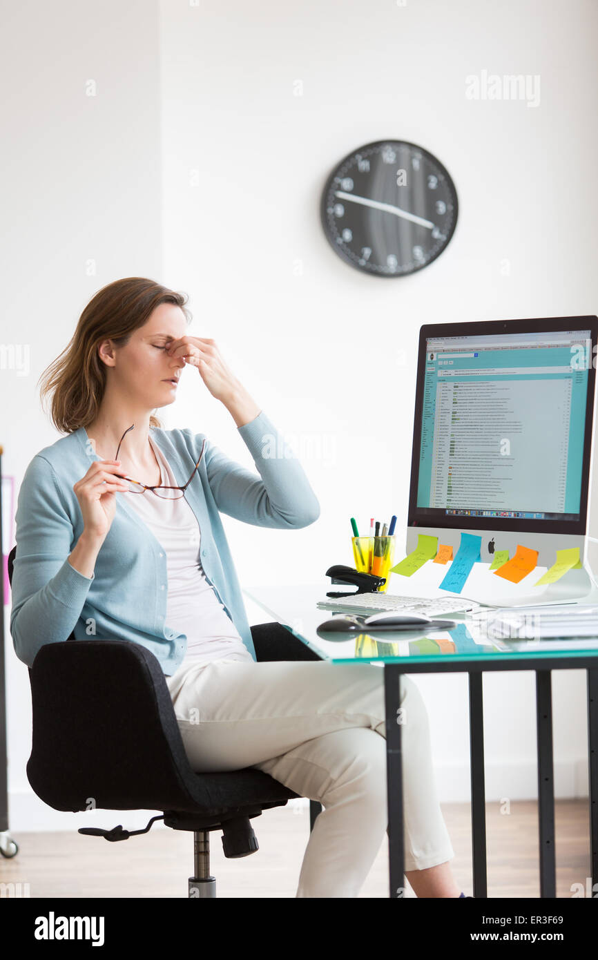 Woman at work suffering from headache. Stock Photo