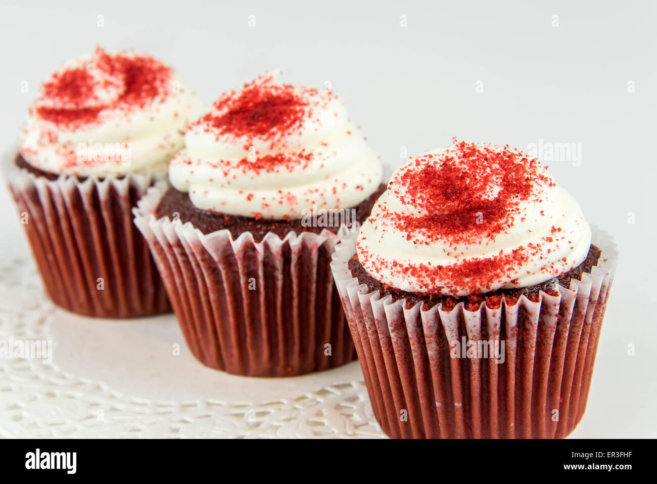red velvet cupcakes with white frosting and red sprinkles Stock Photo