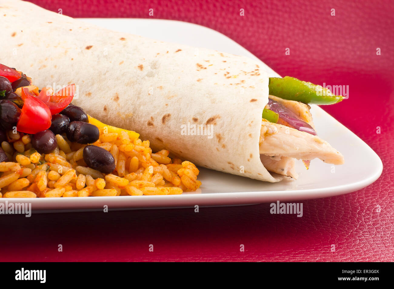 Mexican chicken fajita with green bell pepper slices and red onion in a flour tortilla, with