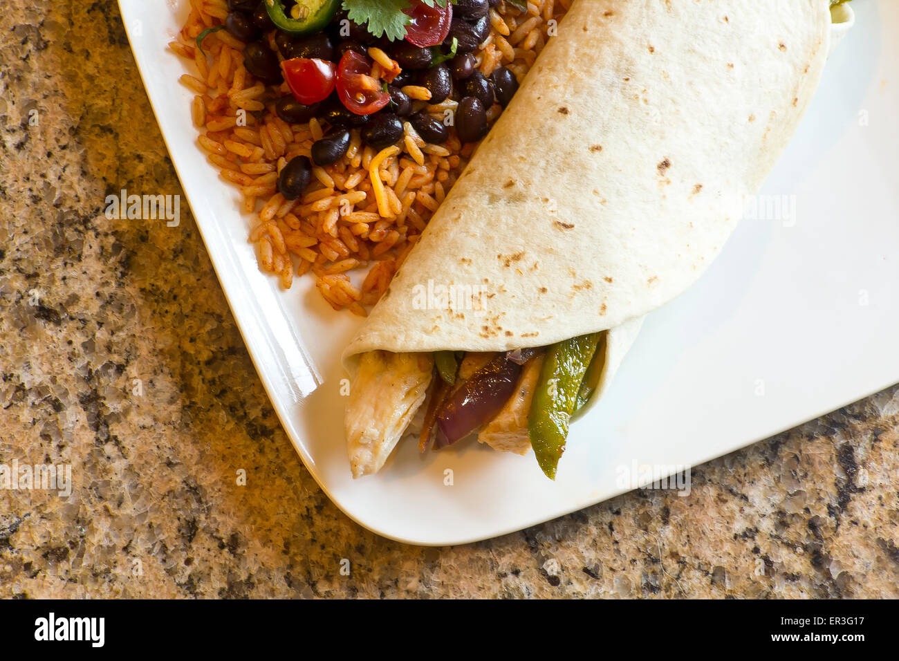 Mexican chicken fajita with green bell pepper slices and red onion in a flour tortilla, with