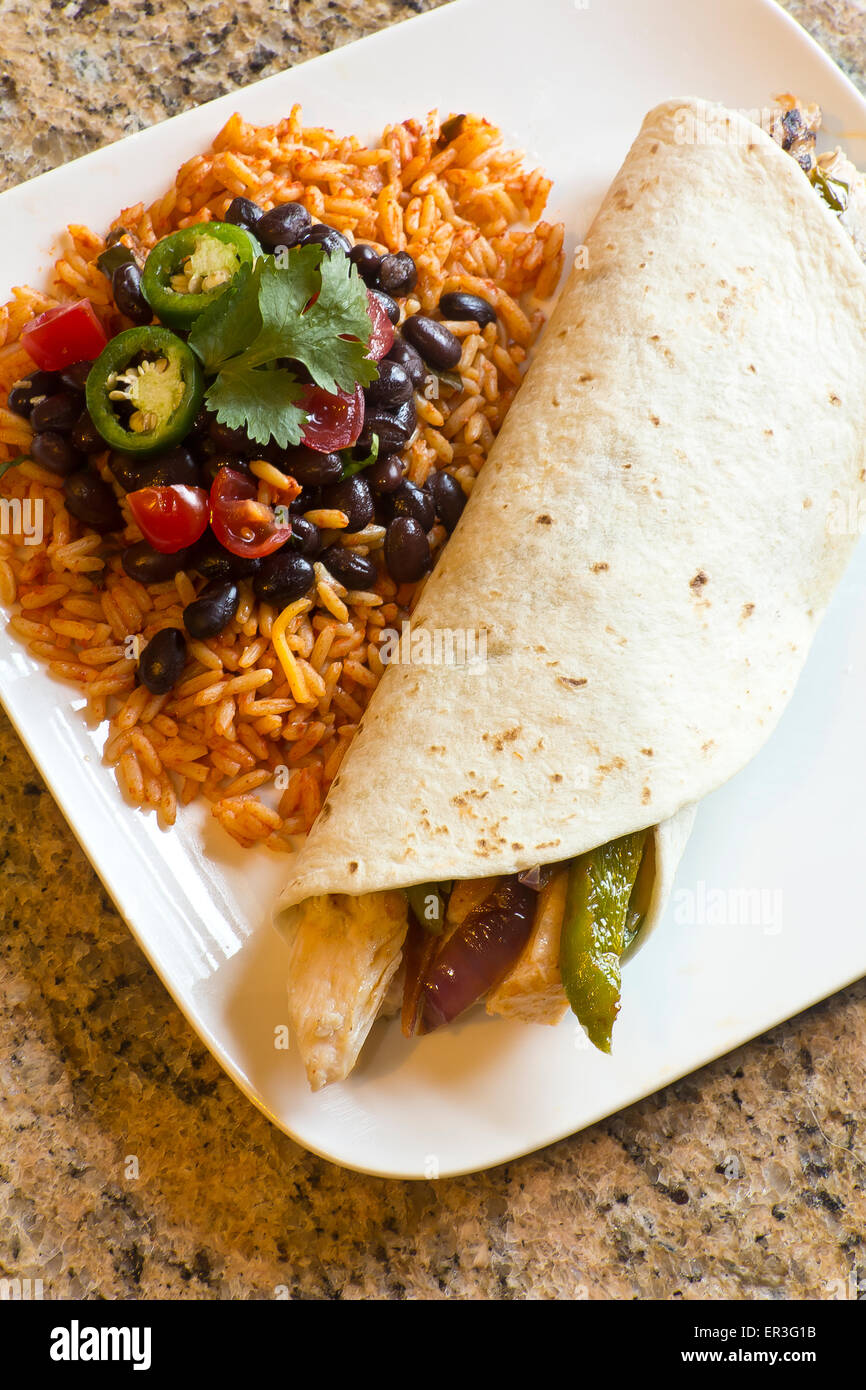 Mexican chicken fajita with green bell pepper slices and red onion in a flour tortilla, with