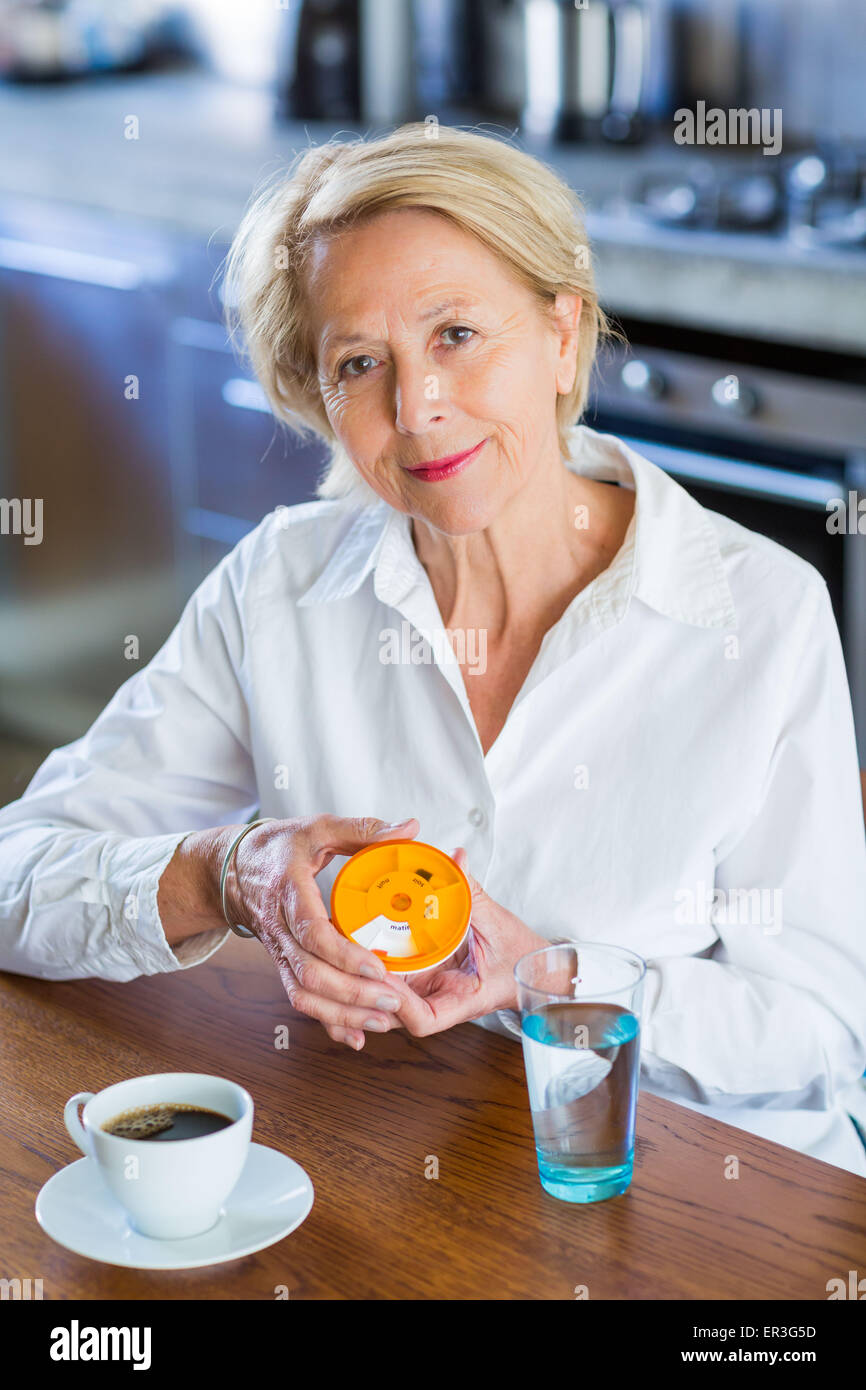 Woman taking medicine from a pillbox. Stock Photo
