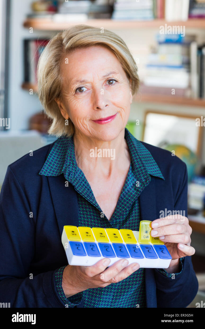 Woman taking medicine from a pillbox. Stock Photo