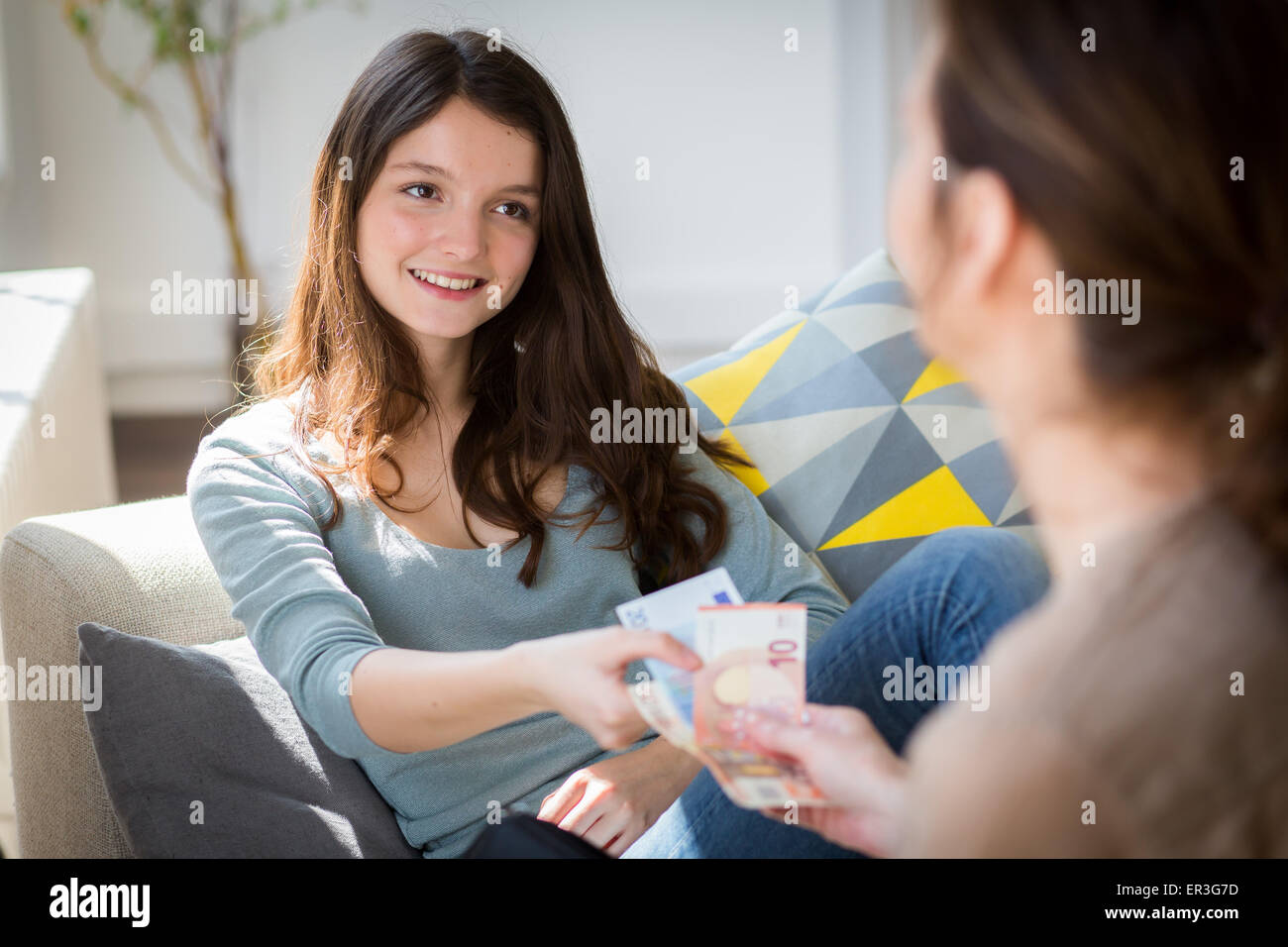 Mother giving her daugther pocket money. Stock Photo