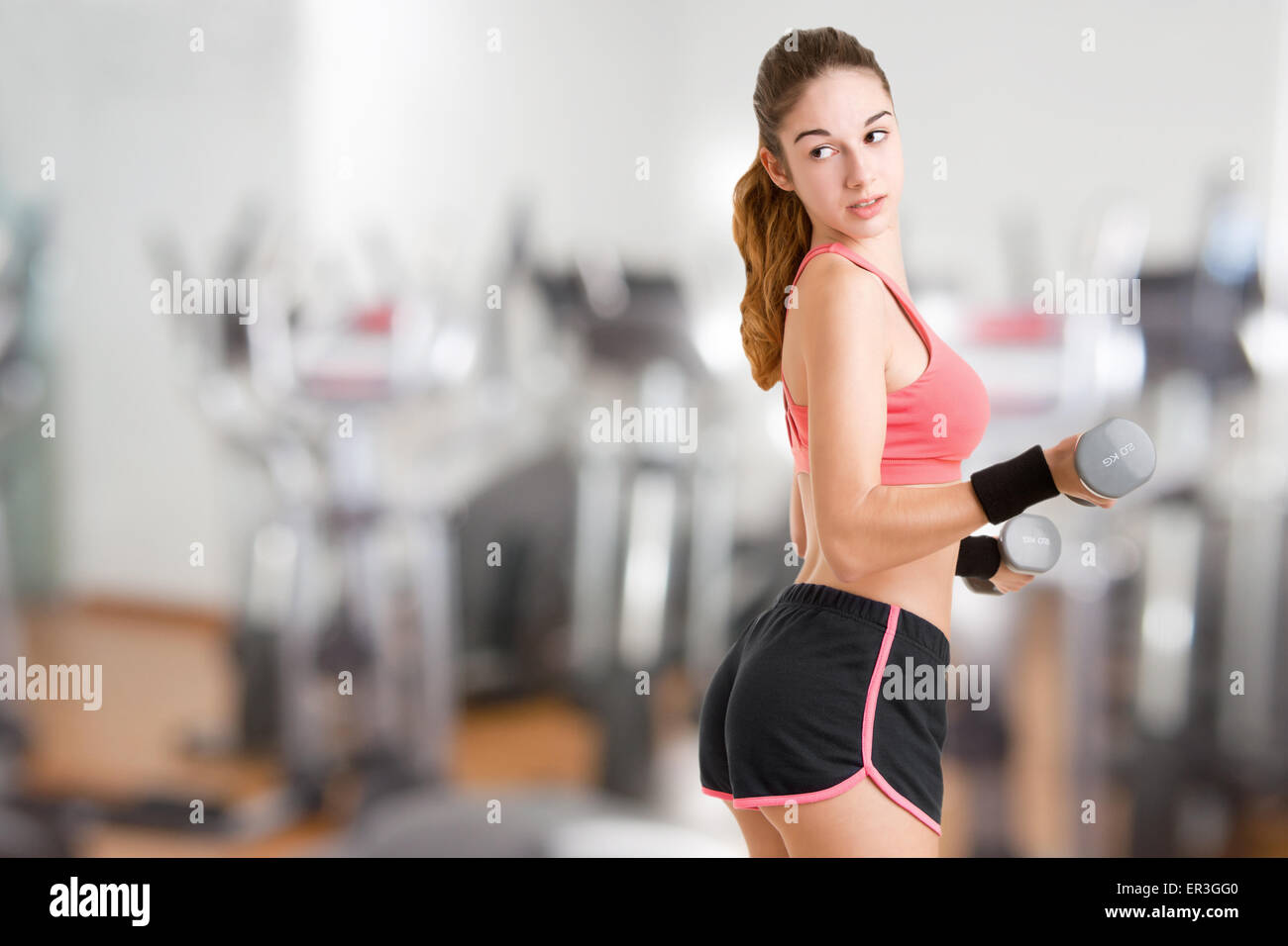 Woman working out with dumbbells at a gym Stock Photo