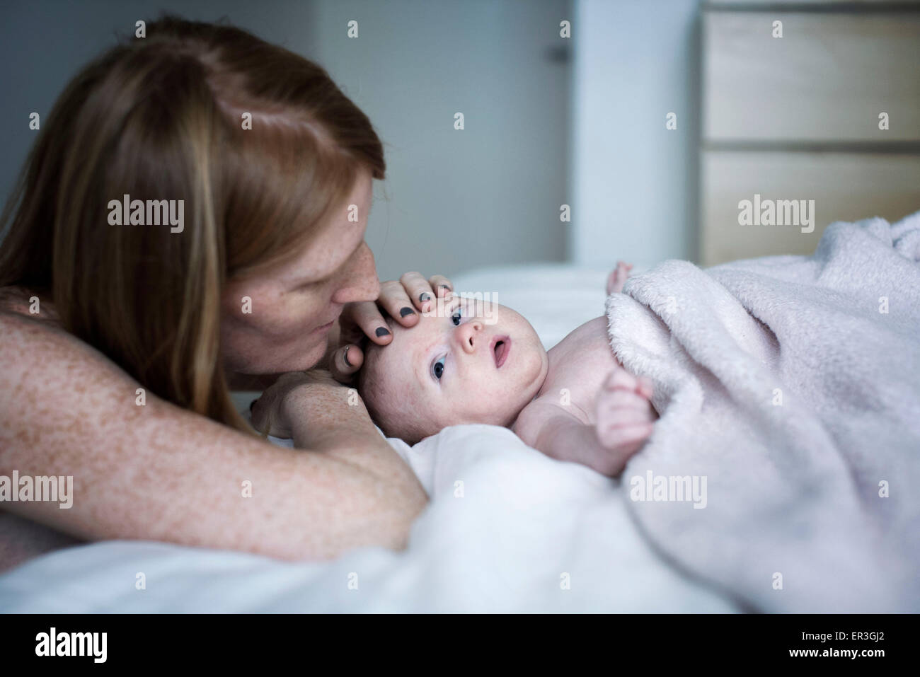 Mother stroking newborn baby's head Stock Photo
