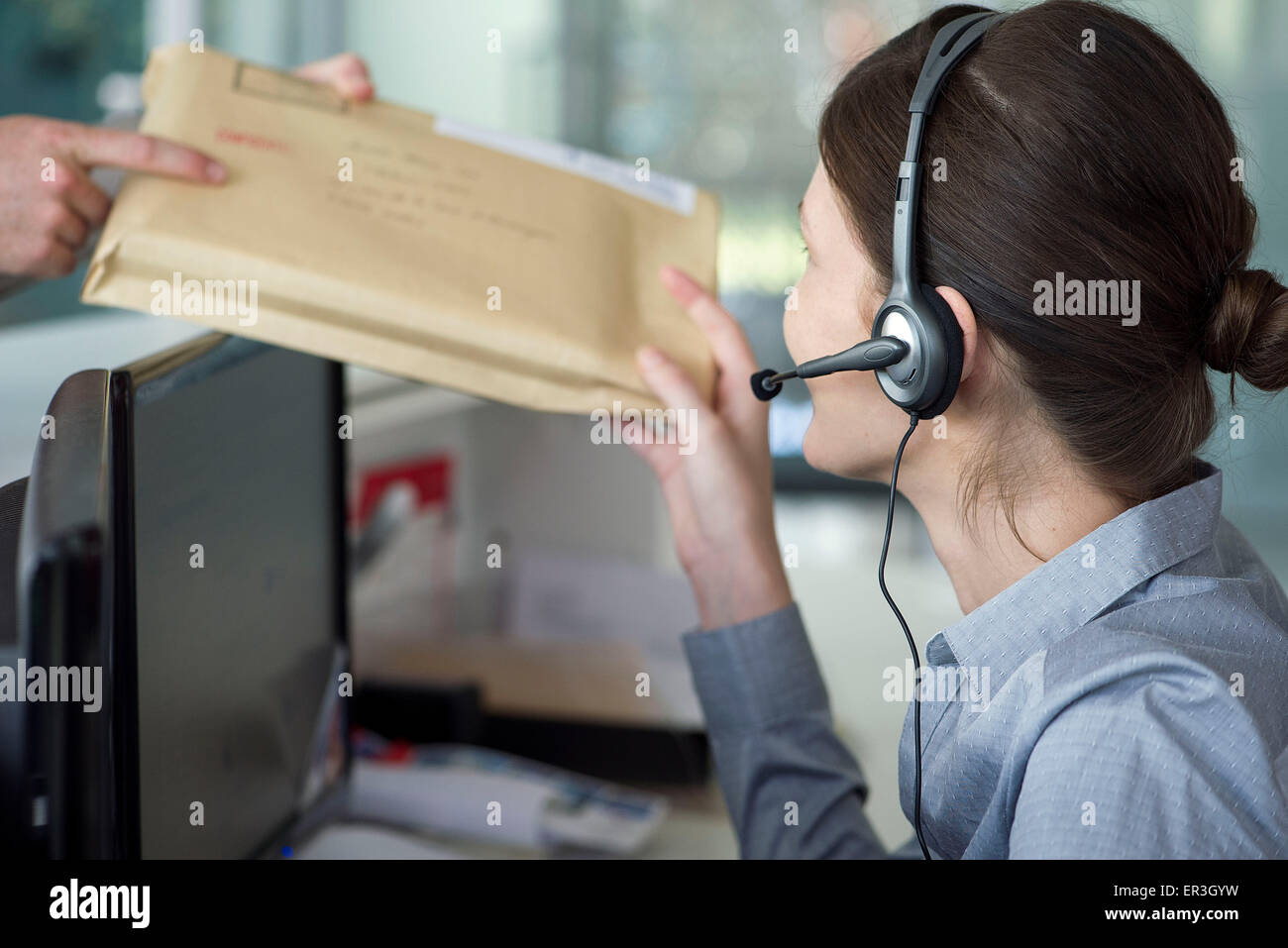 Receptionist receiving mail from delivery person Stock Photo Alamy