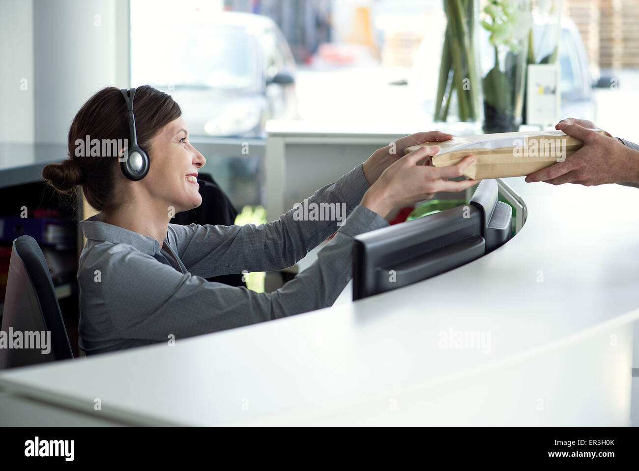 Receptionist accepting package from delivery person Stock Photo Alamy