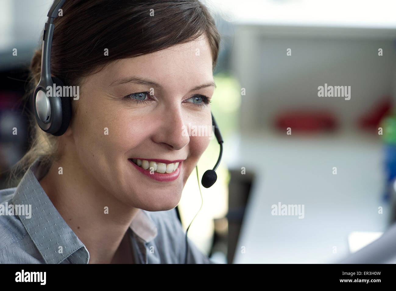 Telemarketer wearing headset, smiling Stock Photo - Alamy