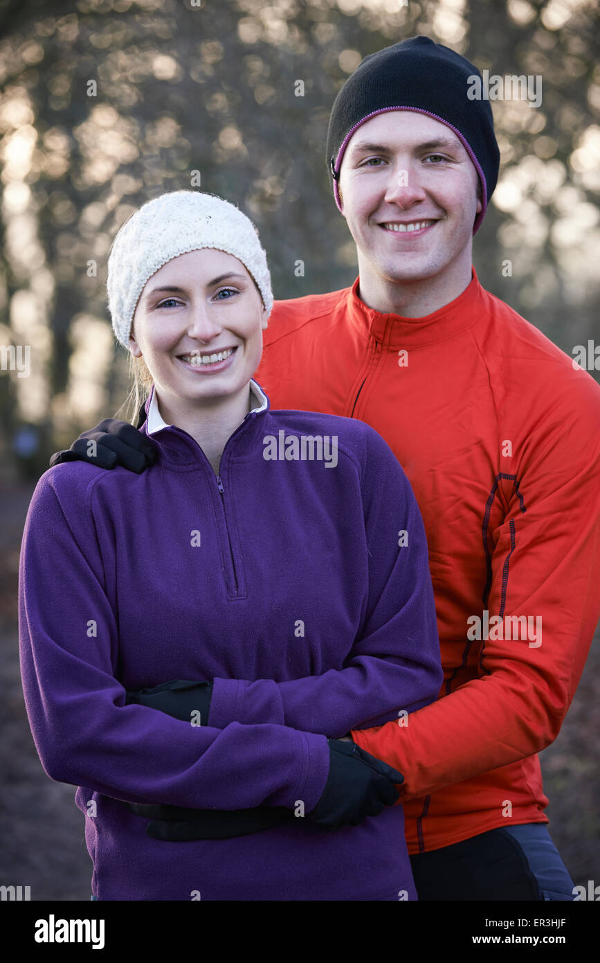 Portrait Of Couple On Winter Run Through Woodland Stock Photo