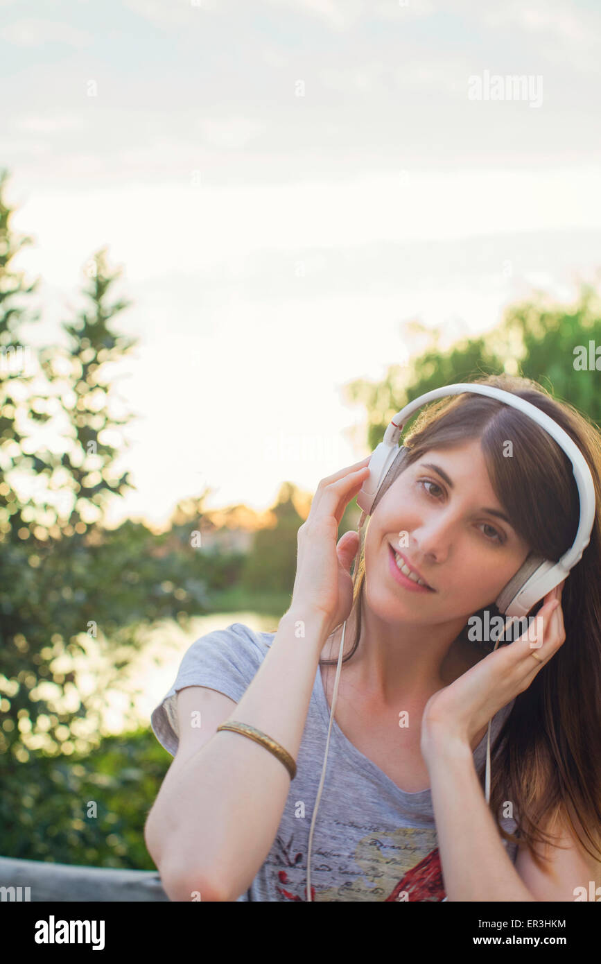 Young woman listening to music through headphones Stock Photo - Alamy