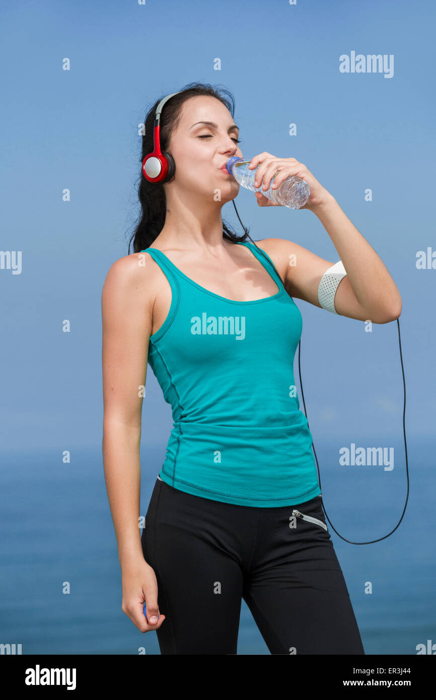 Beautiful young woman drinking after jogging Stock Photo Alamy