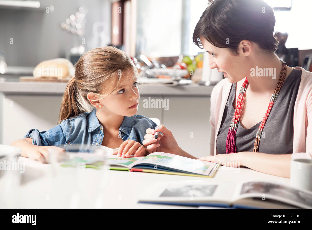 Mother and young daughter reading together Stock Photo