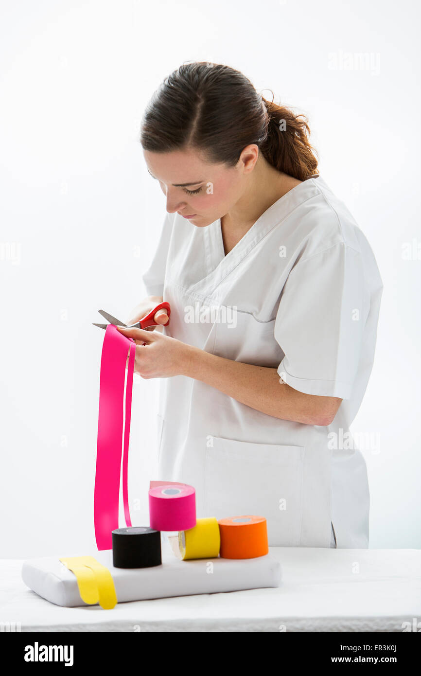 A physiotherapist is preparing the strips for taping Stock Photo