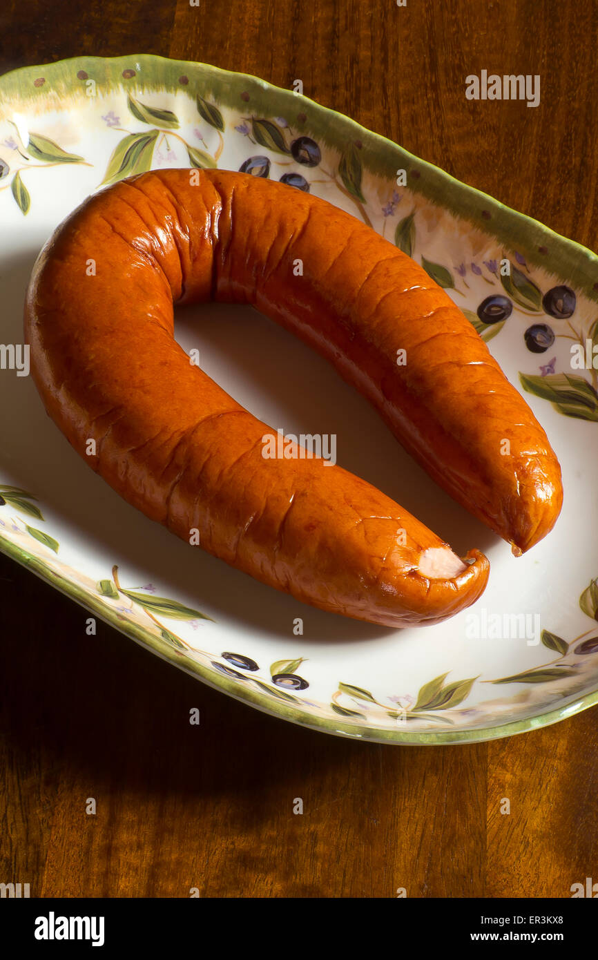 Smoked Polish kielbasa sausage link on a decorative platter Stock Photo