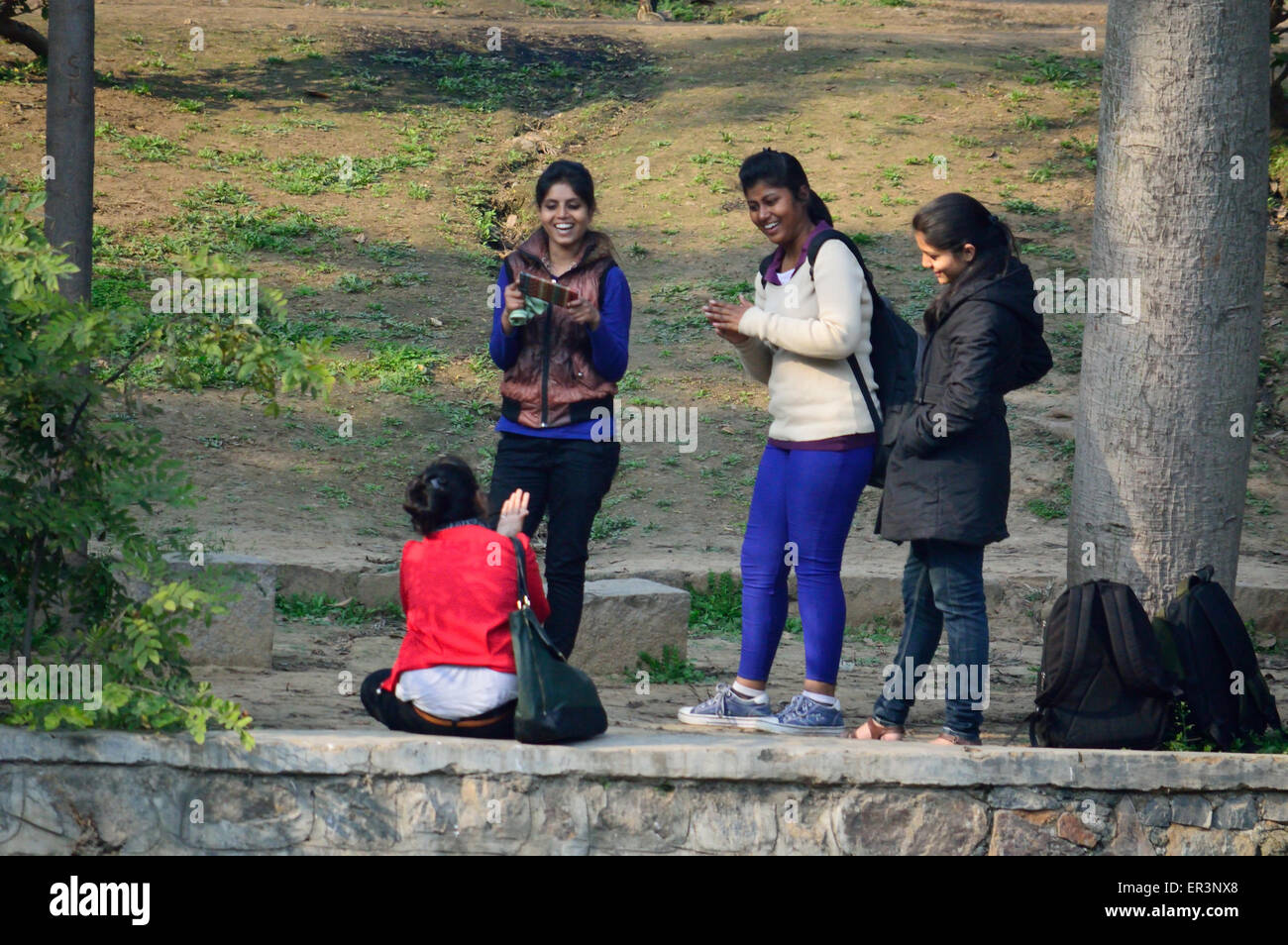 Lodhi Gardens Delhi India 14th Feb 2015 Young college students laughing and shooting mobile pictures Stock Photo