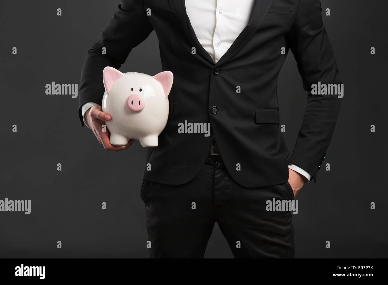 Man in tuxedo holding a pig money box Stock Photo - Alamy
