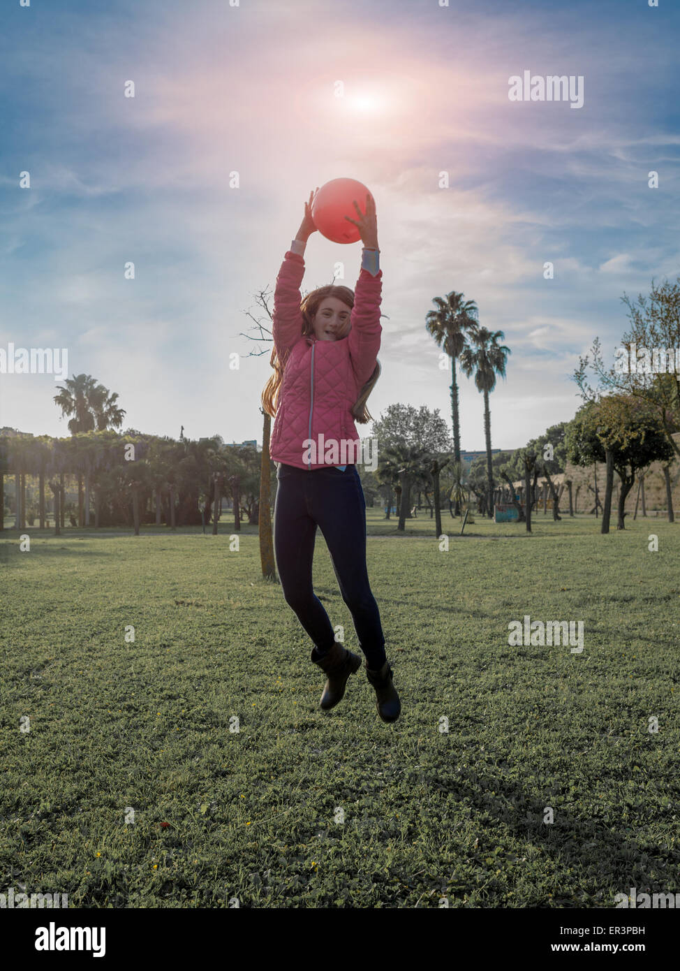 young girl smiling and jumping in the park Stock Photo - Alamy