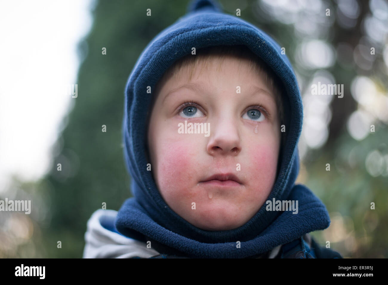 Child crying with tears below the eyes in winter Stock Photo