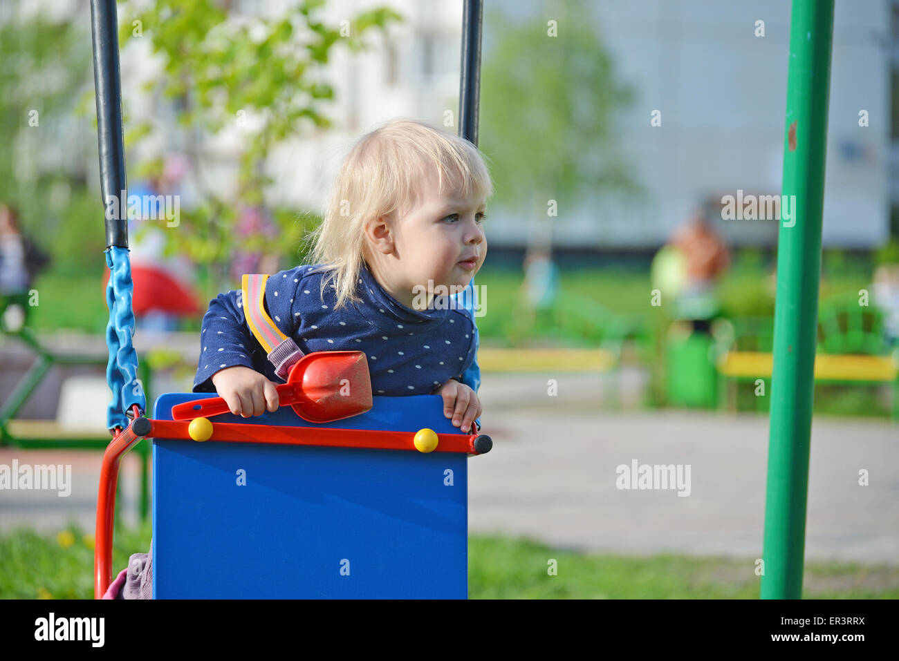 Adorable little girl having fun on a swing outdoor Stock Photo