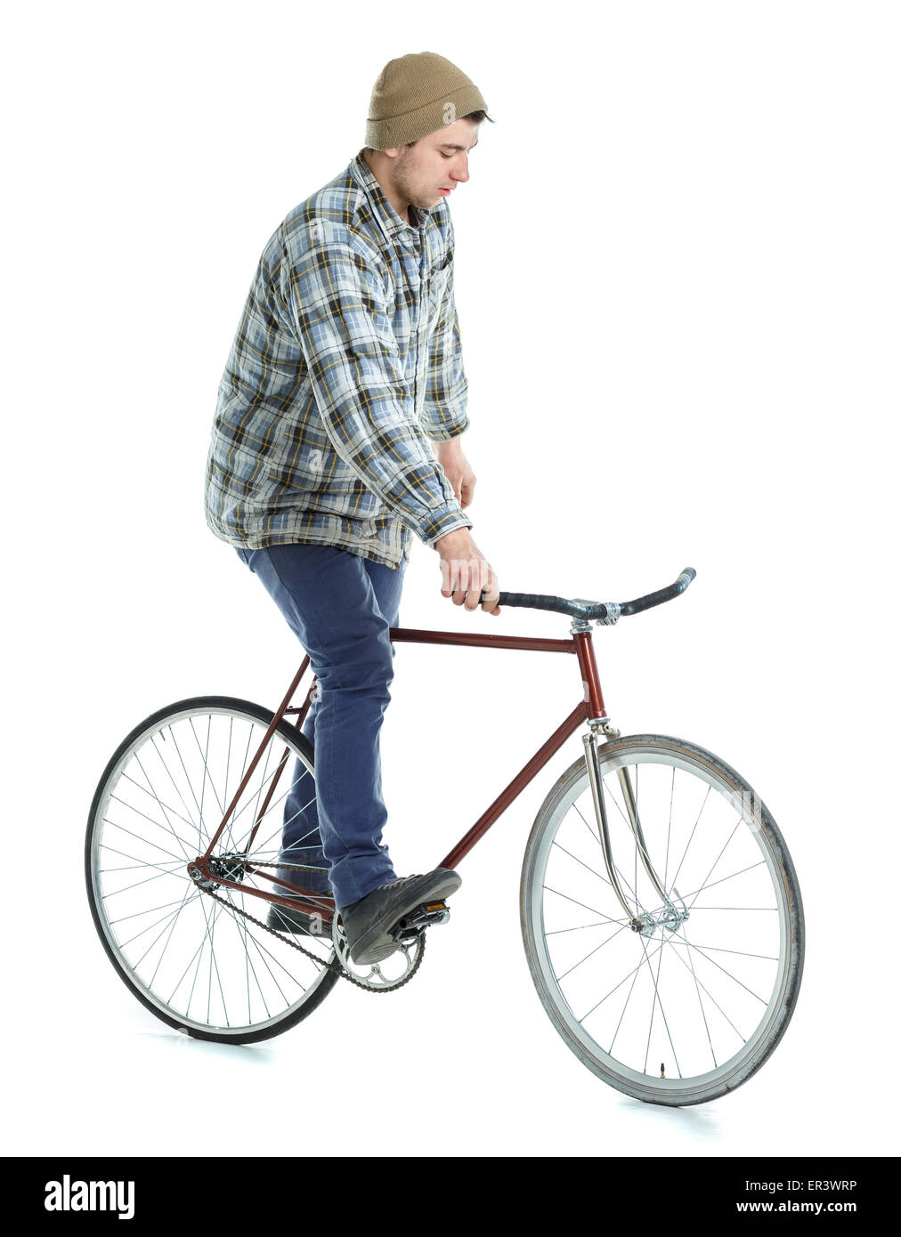 Young man doing tricks on fixed gear bicycle on a white background Stock Photo