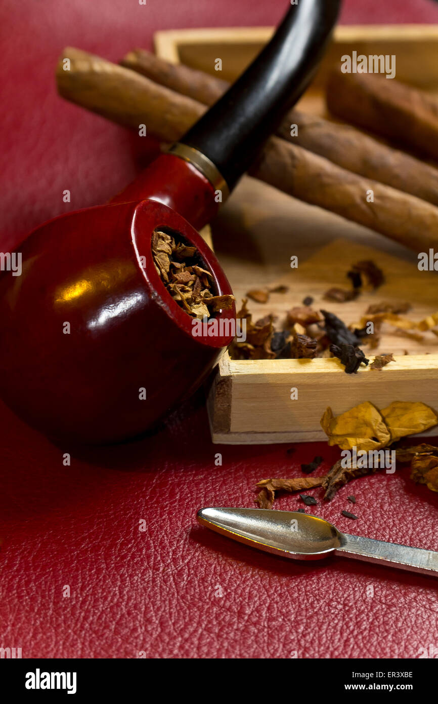 Pipe, tobacco, cigarettes, cigars, smoking, etc. on red leather background  Stock Photo