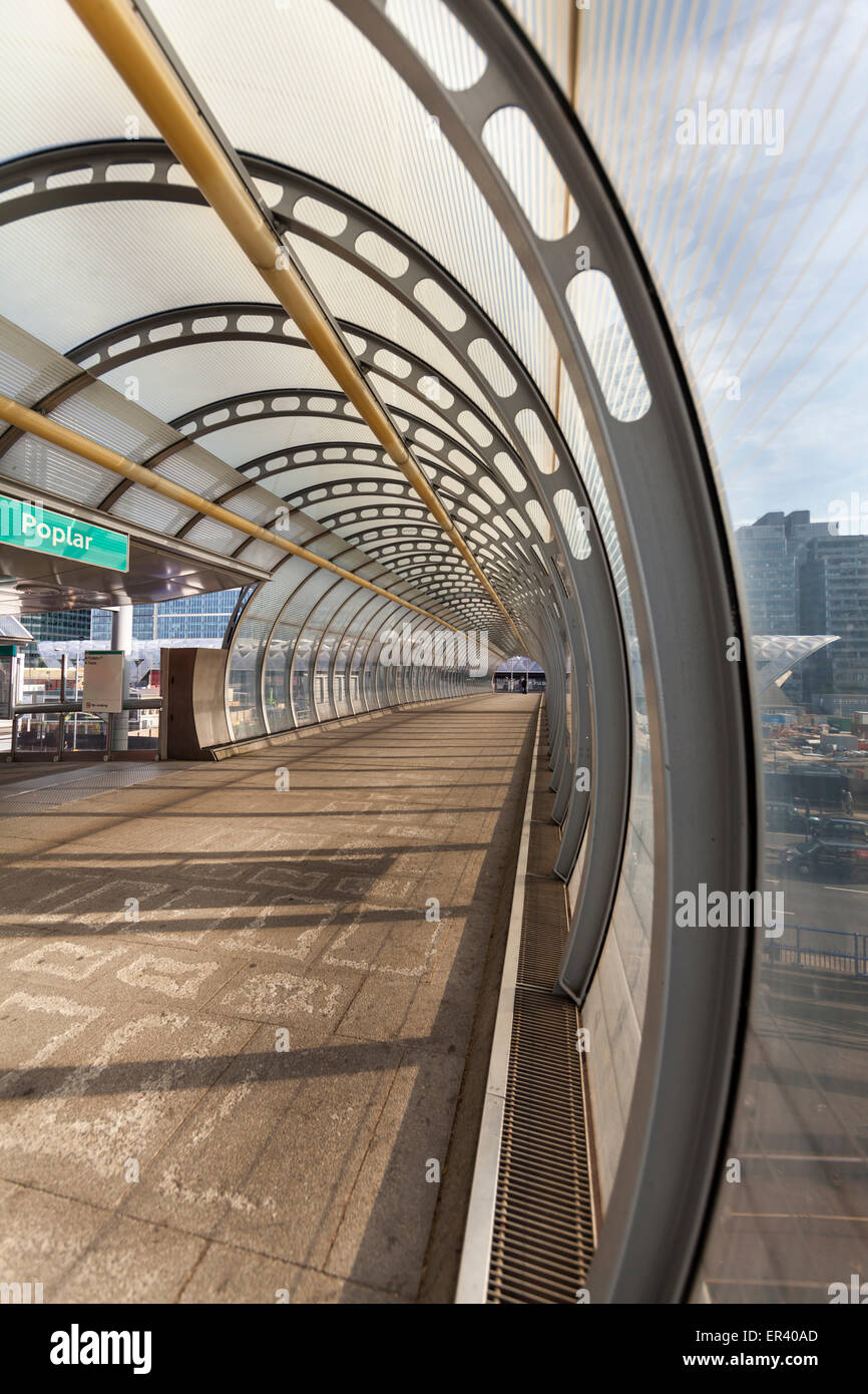 Poplar DLR station high-level walkway, a cable stayed footbridge with curved glass canopy in the London docklands, UK Stock Photo