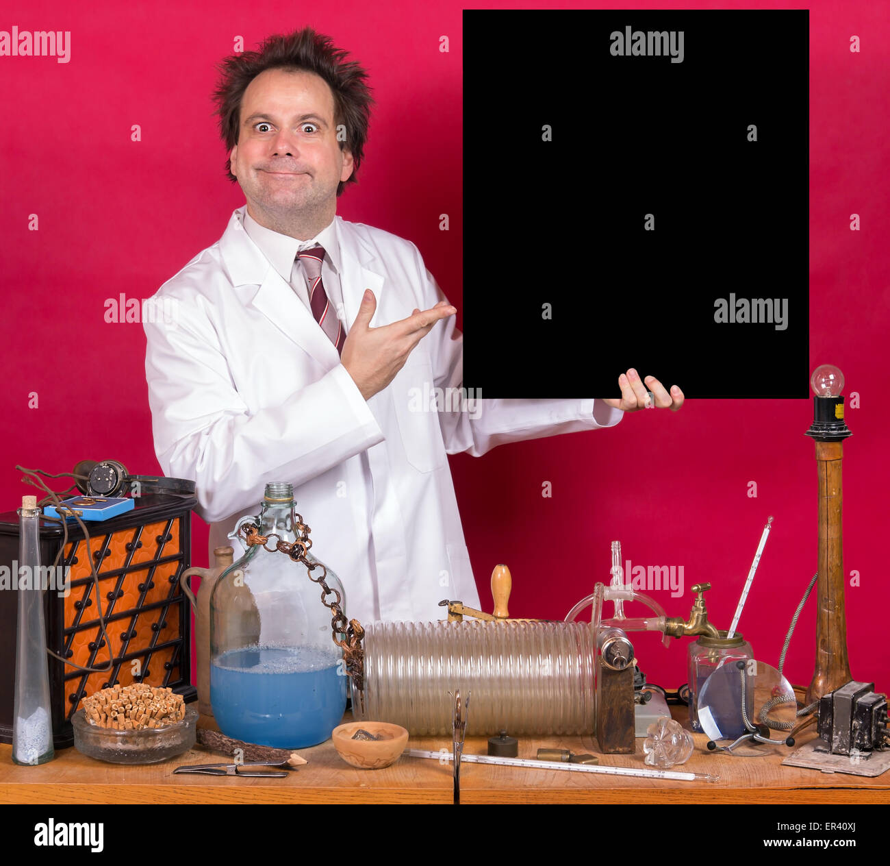 Professor in the laboratory shows on blank blackboard on red background