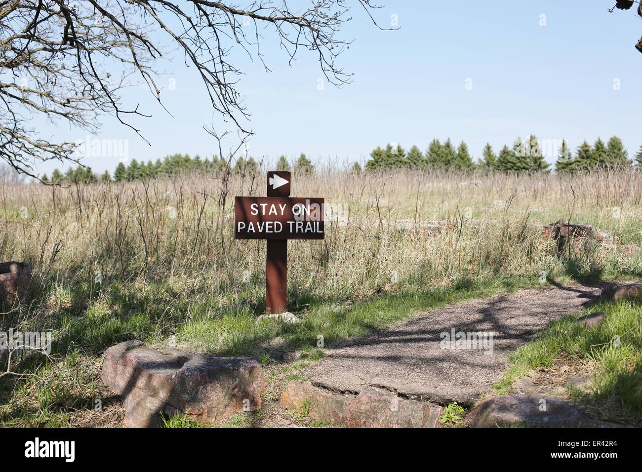 A sign reading stay on paved trail at Pipestone National Monument in Minnesota. Stock Photo