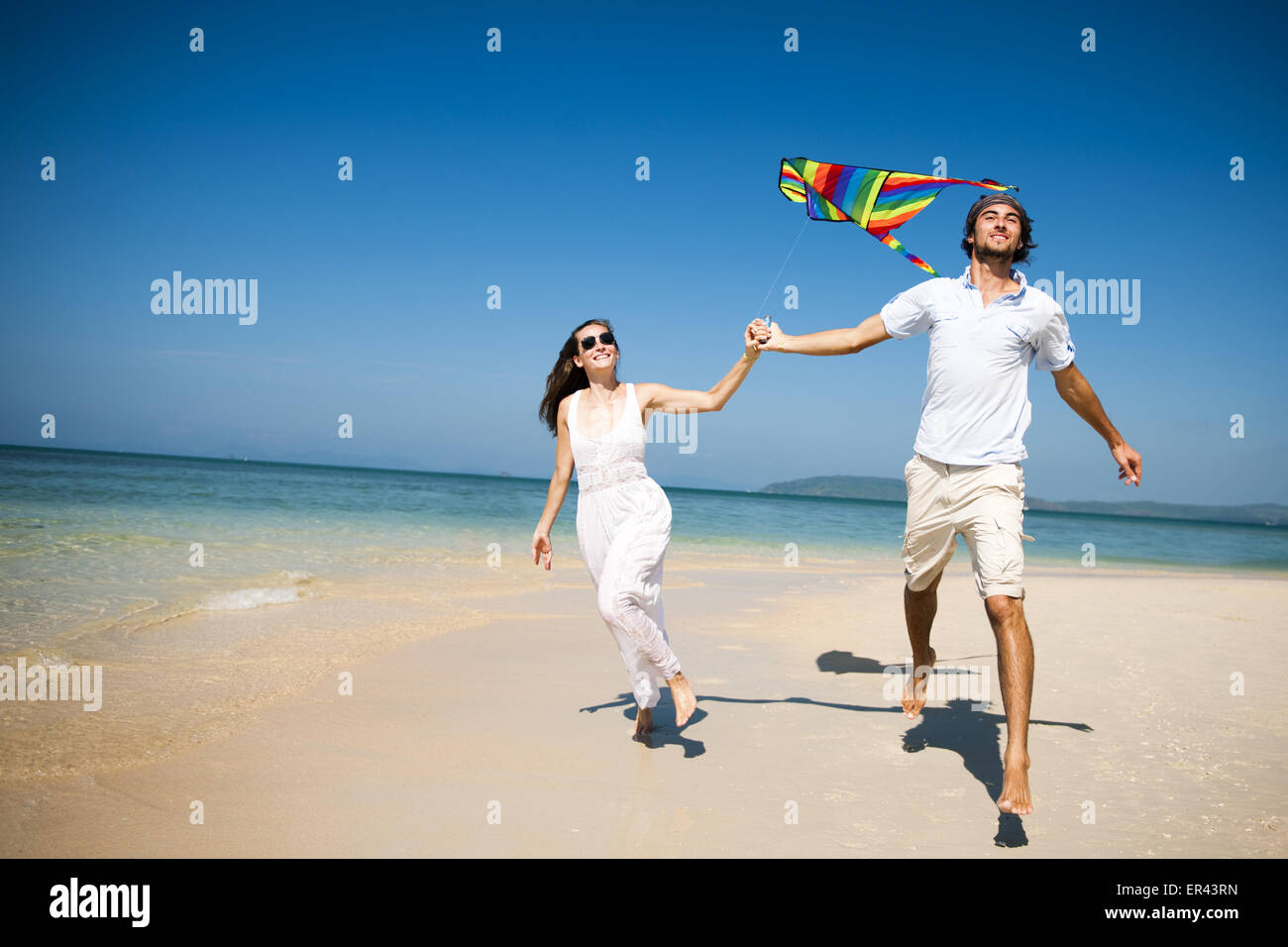 Couple flying kite on beach hi-res stock photography and images - Alamy
