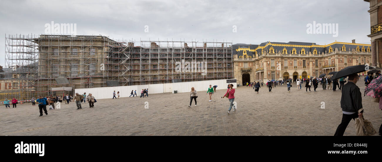 Panorama view showing tourists and restoration and preservation scaffolding on the exterior of the Château de Versailles, France Stock Photo