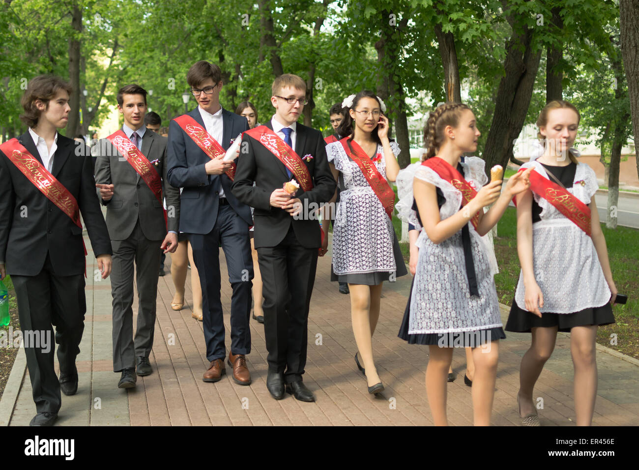Group of Russian schoolchildren in traditional uniform celebrating graduation from high school in May 2015 Stock Photo