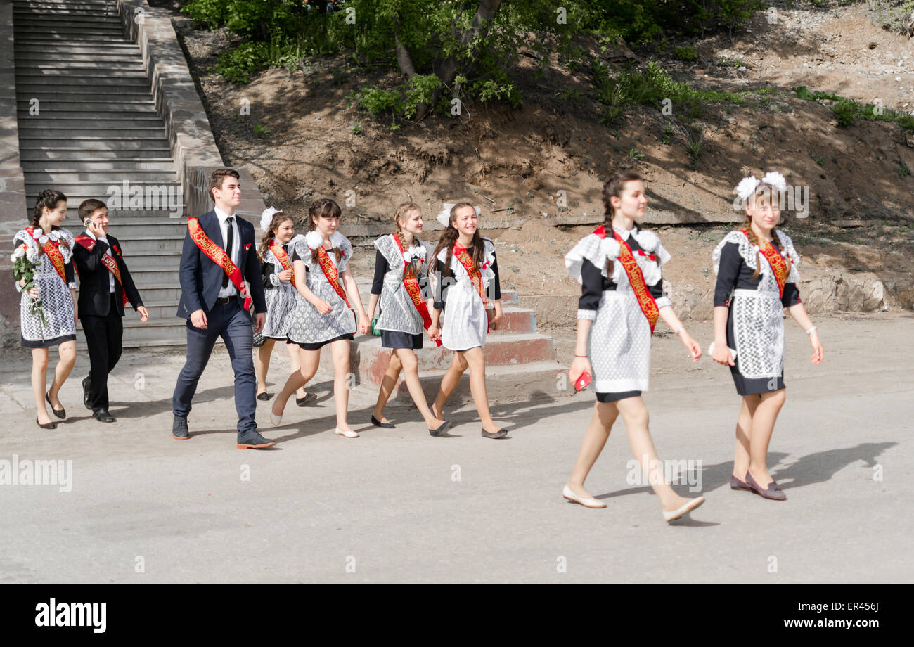 Group of Russian schoolchildren in traditional uniform celebrating graduation from high school in May 2015 Stock Photo