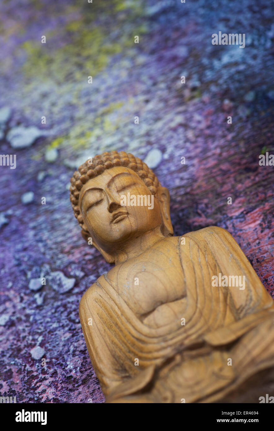 Wooden Buddha on a cosmic painted background Stock Photo