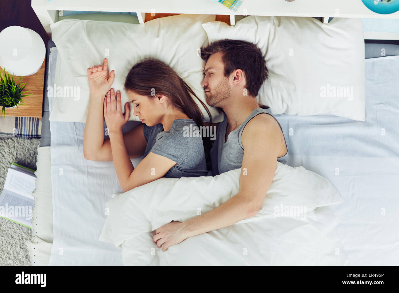 Young couple sleeping in bed under blanket Stock Photo Alamy
