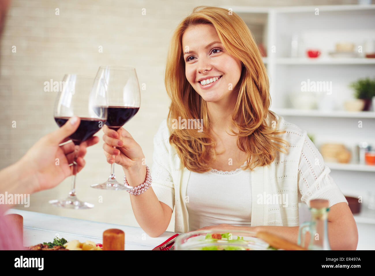 Happy young woman with glass of red wine making toast Stock Photo - Alamy