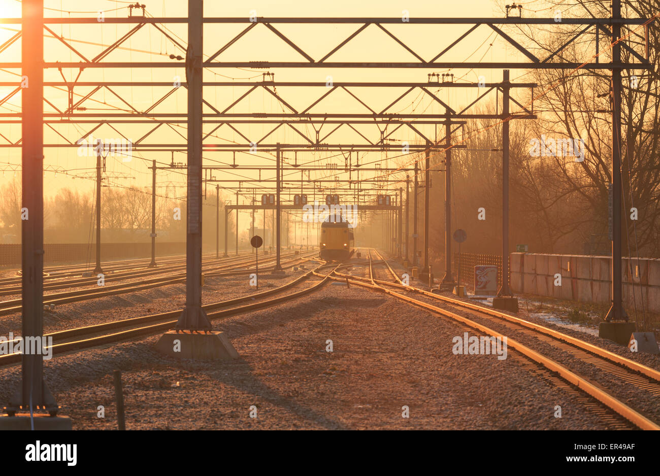 Passenger train and railroad tracks during a nice sunrise. Stock Photo